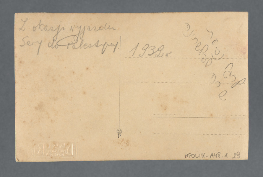 Fotografia grupowa, ustawiana, jaw wynika z opisu - wykonana z okazji wyjazdu koleżanki Mani Żelaznej do Palestyny - Sary, być może Sary Tenenbaum, widocznej, jak się wydaje, w dolnym rzędzie (trzecia od prawej?). Pośrodku przedstawienia wychowawczyni? Znana z innych zdjęć kolekcji, jak się wydaje - m.in. 1.16, 1.28.Mani Żelazna wskazana znakiem długopisowym - strzałką na dolnym marginesie. Wzdłuż dolnej i górnej krawędzi - margines biały o falistej linii, stylizowanej na kształt chmury. Krawędzie odbitki proste.