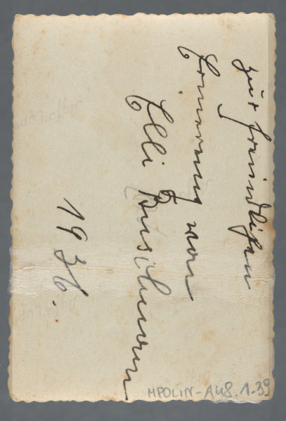 Fotografia przedstawia dwoje dzieci i kobietę na piasku, w tle trawy - być może nieopodal wody (rzeki, jeziora, morza)? Na rewersie dedykacja po niemiecku, z datą 1936, od Elli Busilmann (?).Najprawdopodobniej jedna z pamiątek Hilela Poznera, emigrującego w 1935 r. do Palestyny.Krawędzie ząbkowane.