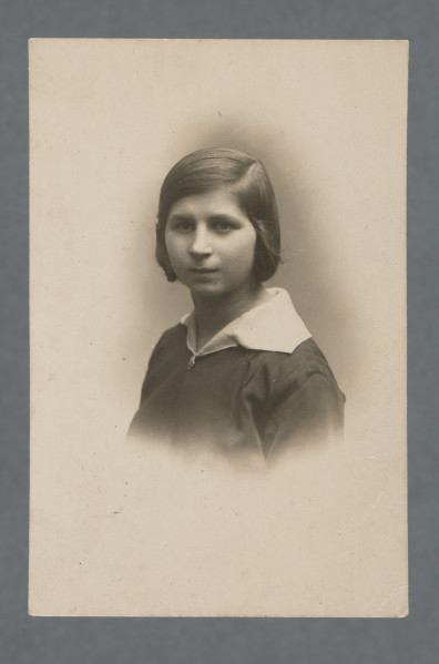 Fotografia monochromatyczna nastoletniej dziewczynki z dużym białym kołnierzykiem wyłożonym na ciemną bluzkę z broszką lub guzikiem czy zapięciem przy dekolcie.Włosy ciemne, zaczesane na lewy bok, za uszy.Pisownia nazwy atelier (FOTOGRAFJA) pozwala stwierdzić, że pieczątka, a zatem najpewniej i fotografia, pochodzi z okresu nie późniejszego niż 1936 (reforma ortografii).Fotografia wywołana z marginesem z rozmytymi krawędziami owalnego obrazu.