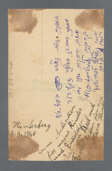 Fotografia monochromatyczna całopostaciowa Hany Hindy z d. Kleczewskiej, matki Hilela Poznera. W ciemnym kostiumie. Twarz uchwycona w trzech czwartych. Fotografia gabinetowa, karta z ząbkowaniem na krawędziach, na neutralnym tle, przy stoliku z obrusem, o który kobieta opiera się lewą ręką. W prawej trzyma torebkę.Na lewej piersi gwiazda Dawida - jako znak dyskryminacyjny. W czasie okupacji niemieckiej znalazła się w Wielkopolsce, w której przez wiele lat (do co najmniej 1918) żyła z mężem. Fotografia wykonana została w Koninie, dedykacja napisana w odległym o 30 km od Konina Zagórowie. Możemy przypuszczać, że do Zagórowa została przesiedlona z grupami innych Żydów z Konina, których część trafiła do getta w Zagórowie funkcjonującego w 1940–1942; przebywało w nim 2,5 tys. osób, rozstrzelanych później w pobliskich lasach kazimierzowskich - nie wiemy, czy kobieta zginęła w tym mordzie, czy trafiła do funkcjonującego na przełomie 1942/1943 obozu pracy przymusowej dla Żydów. Od darczyńcy wiadomo, że fotografia zachowała się, ponieważ została przesłana do rodziny w Portugalii - dedykacja z rewersu wskazuje, że wysyłana była do Salomona Perela i Fiszela.Na rewersie ślady po karcie albumu, do którego zdjęcie było przyklejone, przebarwienia po kleju.