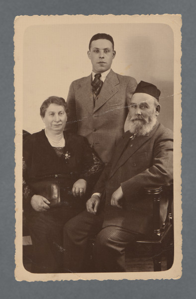 Fotografia trzech osób: Hana Hinda z d. Kleczewska, Hilel Pozner (stoi), Zelig Josek Pozner. Wzdłuż krawędzi prostokątny jasny margines, zaokrąglony w rogach. Krawędzie ząbkowane.Na rewersie w lewym górny rogu podkreślone 6. Od darczyńcy wiadomo, że fotografia zachowała się, ponieważ została przesłana - być może już w okresie wojny - do Portugalii.