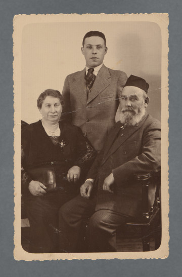 Fotografia trzech osób: Hana Hinda z d. Kleczewska, Hilel Pozner (stoi), Zelig Josek Pozner. Wzdłuż krawędzi prostokątny jasny margines, zaokrąglony w rogach. Krawędzie ząbkowane.Na rewersie w lewym górny rogu podkreślone 6. Od darczyńcy wiadomo, że fotografia zachowała się, ponieważ została przesłana - być może już w okresie wojny - do Portugalii.