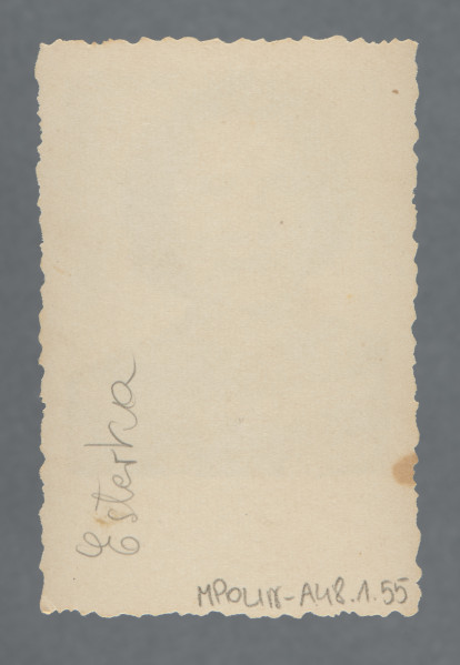 Fotografia monochromatyczna, portretowa kobiety, en face, popiersie; w paskowanej bluzce, z mocno kręcącymi się włosami, ciemnymi. Uśmiecha się. Tło białe. Kadr niesymetryczny (sylwetka wyraźnie po lewej).Krawędzie ząbkowane, wzdłuż nich prostokątny margines, największy przy dolnej krawędzi.