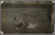 Fotografia Feli Cytrynówny w plenerze, jak wynika z opisu ręką Mani Żelaznej (?) na odwrocie: młoda kobieta leży bokiem w ciemnym stroju kąpielowym na trawie lub wśród ziół, patrzy w obiektyw. Nie uśmiecha się.Fotografia wywołana z białymi narożnikami, prawa i górna krawędzie z pasmem nienależącym do obrazu zdjęcia - fotografia być może przefotografowana. Krawędzie odbitki proste.Por. zdjęcie grupowe w kolekcji - 1.13, na nim również jest, wg opisu, przedstawiona Fela Cytrynówna.