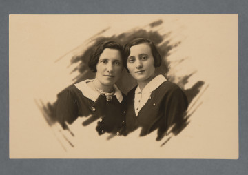 Fotografia kobiety (wychowawczyni Głównego Domu Schronienia?, widnieje także na innych zdjęciach kolekcji, np. 1.16) i młodej kobiety, zapewne koleżanki Mani Żelaznej.Karta prostokątna, z krawędziami prostymi, obraz wywołany nie na całej karcie - pośrodku, z ozdobnie rozmazanymi krawędziami obrazu.Na odwrocie nadruk: CARTE POSTALE.