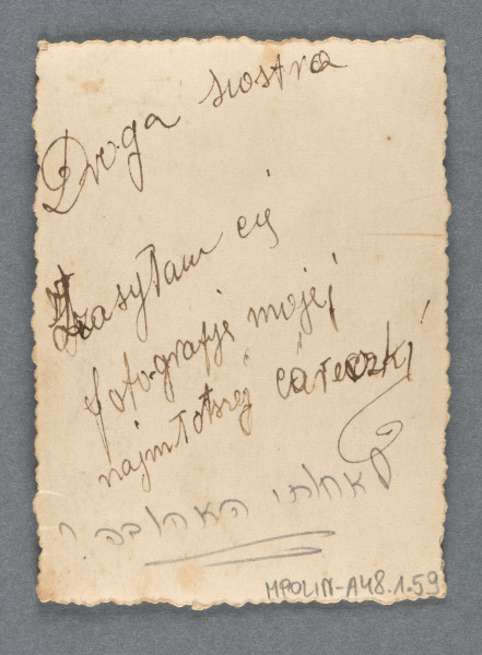 Fotografia monochromatyczna dziewczynki, około 2-3-letniej, z jasnymi włosami za szyję, w sukience, z ciemną piłką w jasne kropki pod pachą, stojącej obok krzewu. Ma wysokie buty i białe skarpetki. Stoi na wprost (ujęcie całopostaciowe), patrzy w obiektyw. Z opisu wynika, że jest to siostrzenica Mani Żelaznej, córka nieznanej nam z imienia siostry. Ta część rodziny została zabita w Zagładzie.Krawędzie ząbkowane.