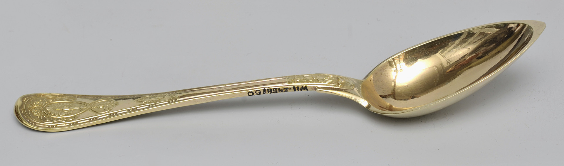 ujęcie 3/4 - widoczna wewnętrzna strona czerpaka. Ujęcie z nabierakiem po prawej stronie i napisem inwentarzowym na bocznej krawędzi rączki.