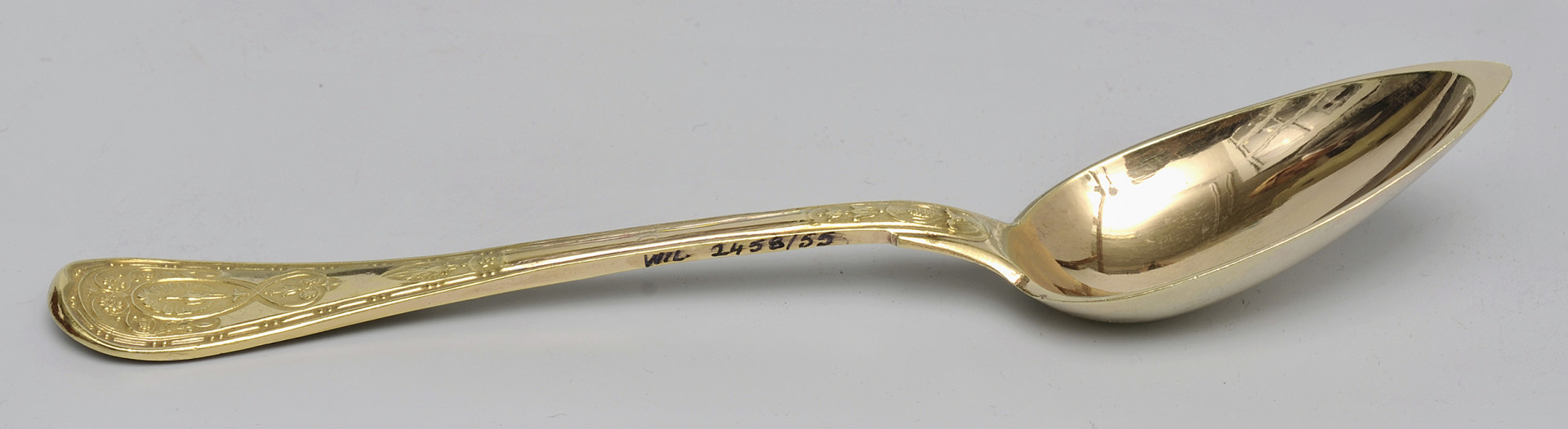 ujęcie 3/4 - widoczna wewnętrzna strona czerpaka. Ujęcie z nabierakiem po prawej stronie i napisem inwentarzowym na bocznej krawędzi rączki.