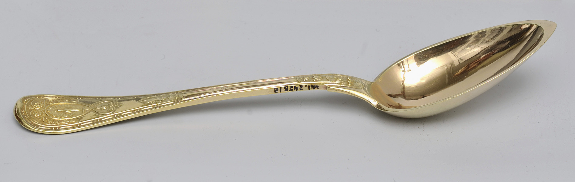 ujęcie 3/4 - widoczna wewnętrzna strona czerpaka. Ujęcie z nabierakiem po prawej stronie i napisem inwentarzowym na bocznej krawędzi rączki.