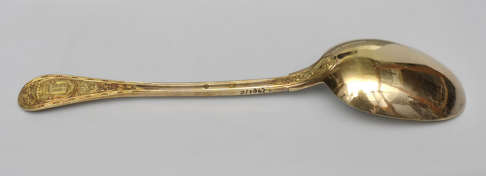 ujęcie 3/4 - widoczna zewnętrzna strona czerpaka. Nabierak po prawej stronie; na bocznej krawędzi rączki napis inwentarzowy.