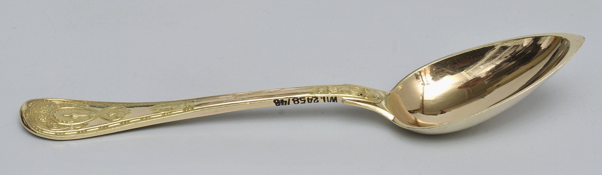 ujęcie 3/4 - widoczna wewnętrzna strona czerpaka. Ujęcie z nabierakiem po prawej stronie i napisem inwentarzowym na bocznej krawędzi rączki.