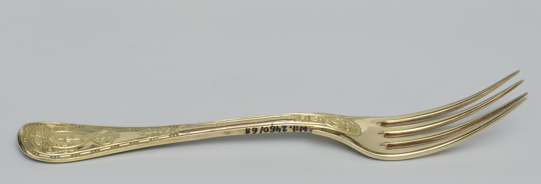 ujęcie 3/4 – od strony awersu. Ujęcie z zębiskami po prawej stronie i napisem inwentarzowym w górnej części bocznej krawędzi rączki.