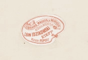 zbliżenie na naklejkę na rewersie karty albumu. Wklejka w kształcie palety malarskiej, na której napis: Librairie, Magasin de Musique et Salon Artistique Léon Idzikowski Kieff Maison Popoff