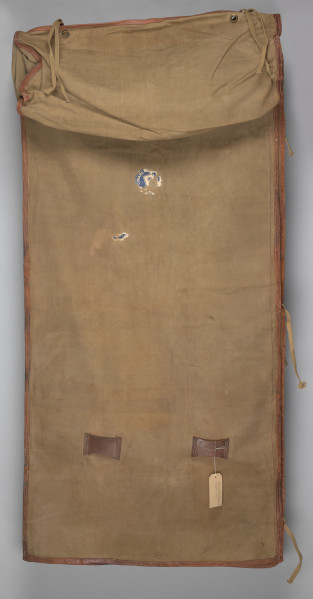 Śpiwór uszyty z płótna bawełnianego o grubym splocie w kolorze jasnobrązowym. Śpiwór posiada kształt kopertowy. Konstrukcja śpiwora składa się ze środkowej płaszczyzny w formie długiej kieszeni zakrywającej ciało. Kieszeń zamykana jest na dwie klapy: lewa, mniejsza, oraz prawa, szersza. Śpiwór posiada dwie kieszenie: dolną w formie prostokąta, górną, która może stanowić rodzaj ochraniacza, w który można zrolować całość. Wykończenie śpiwora wykonane jest ze skórzanej lamówki, znajduję się ona na całej długości, a także na wewnętrznych krawędziach śpiwora. Duża klapa posiada na brzegu rozłożone symetryczne trzy metalowe nity. W przeciwległym rogu śpiwora przyszyte są bawełniane sznurki. Na brzegach pokrowca znajdują się również dwa nity i dwa troki przyszyte do brzegów podszewki.
W dolnej partii śpiwora; na zewnętrznej stronie, znajdują się dwie skórzane szlufki.
Dodatkowo w środkowej partii znajduję się papierowa, okrągła nalepka (destrukt). Na nalepce widoczna litera B w kolorze granatowym.