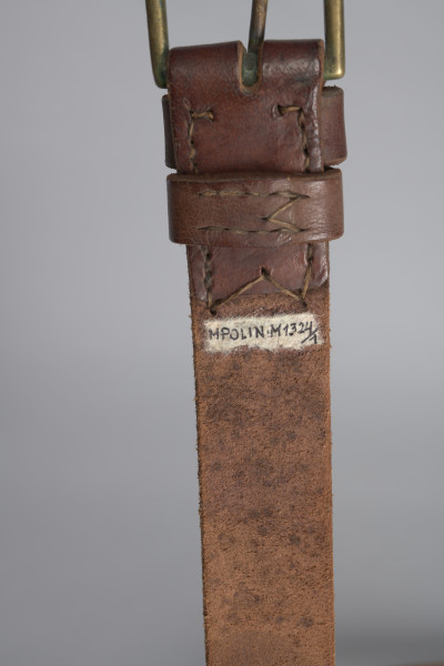 Śpiwór uszyty z płótna bawełnianego o grubym splocie w kolorze jasnobrązowym. Śpiwór posiada kształt kopertowy. Konstrukcja śpiwora składa się ze środkowej płaszczyzny w formie długiej kieszeni zakrywającej ciało. Kieszeń zamykana jest na dwie klapy: lewa, mniejsza, oraz prawa, szersza. Śpiwór posiada dwie kieszenie: dolną w formie prostokąta, górną, która może stanowić rodzaj ochraniacza, w który można zrolować całość. Wykończenie śpiwora wykonane jest ze skórzanej lamówki, znajduję się ona na całej długości, a także na wewnętrznych krawędziach śpiwora. Duża klapa posiada na brzegu rozłożone symetryczne trzy metalowe nity. W przeciwległym rogu śpiwora przyszyte są bawełniane sznurki. Na brzegach pokrowca znajdują się również dwa nity i dwa troki przyszyte do brzegów podszewki.
W dolnej partii śpiwora; na zewnętrznej stronie, znajdują się dwie skórzane szlufki.
Dodatkowo w środkowej partii znajduję się papierowa, okrągła nalepka (destrukt). Na nalepce widoczna litera B w kolorze granatowym.