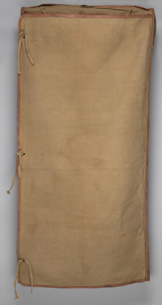 Śpiwór uszyty z płótna bawełnianego o grubym splocie w kolorze jasnobrązowym. Śpiwór posiada kształt kopertowy. Konstrukcja śpiwora składa się ze środkowej płaszczyzny w formie długiej kieszeni zakrywającej ciało. Kieszeń zamykana jest na dwie klapy: lewa, mniejsza, oraz prawa, szersza. Śpiwór posiada dwie kieszenie: dolną w formie prostokąta, górną, która może stanowić rodzaj ochraniacza, w który można zrolować całość. Wykończenie śpiwora wykonane jest ze skórzanej lamówki, znajduję się ona na całej długości, a także na wewnętrznych krawędziach śpiwora. Duża klapa posiada na brzegu rozłożone symetryczne trzy metalowe nity. W przeciwległym rogu śpiwora przyszyte są bawełniane sznurki. Na brzegach pokrowca znajdują się również dwa nity i dwa troki przyszyte do brzegów podszewki.
W dolnej partii śpiwora; na zewnętrznej stronie, znajdują się dwie skórzane szlufki.
Dodatkowo w środkowej partii znajduję się papierowa, okrągła nalepka (destrukt). Na nalepce widoczna litera B w kolorze granatowym.