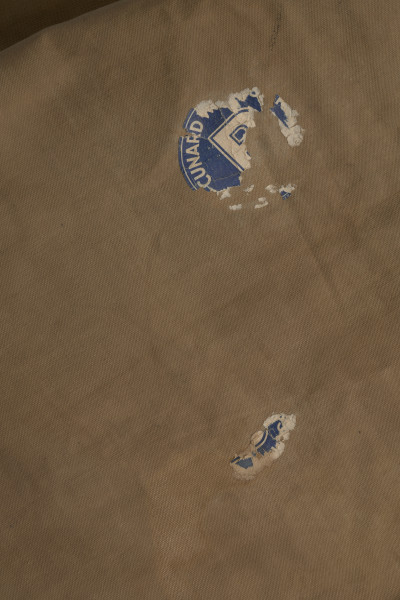 Śpiwór uszyty z płótna bawełnianego o grubym splocie w kolorze jasnobrązowym. Śpiwór posiada kształt kopertowy. Konstrukcja śpiwora składa się ze środkowej płaszczyzny w formie długiej kieszeni zakrywającej ciało. Kieszeń zamykana jest na dwie klapy: lewa, mniejsza, oraz prawa, szersza. Śpiwór posiada dwie kieszenie: dolną w formie prostokąta, górną, która może stanowić rodzaj ochraniacza, w który można zrolować całość. Wykończenie śpiwora wykonane jest ze skórzanej lamówki, znajduję się ona na całej długości, a także na wewnętrznych krawędziach śpiwora. Duża klapa posiada na brzegu rozłożone symetryczne trzy metalowe nity. W przeciwległym rogu śpiwora przyszyte są bawełniane sznurki. Na brzegach pokrowca znajdują się również dwa nity i dwa troki przyszyte do brzegów podszewki.
W dolnej partii śpiwora; na zewnętrznej stronie, znajdują się dwie skórzane szlufki.
Dodatkowo w środkowej partii znajduję się papierowa, okrągła nalepka (destrukt). Na nalepce widoczna litera B w kolorze granatowym.