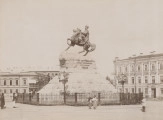zbliżenie na zdjęcie przedstawiające pomnik hetmana na koniu. Monument na wysokim cokole, na którym niezachowana do dziś tablica inskrypcyjna głoszącą: „Bogdanowi Chmielnickiemu jedna niepodzielna Rosja”. Całość otoczona ażurowym, metalowym parkanem