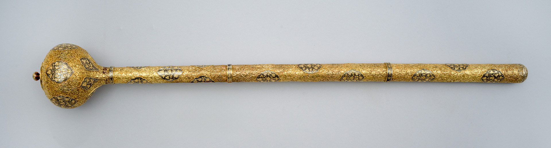 strona druga. Rękojeść z trzema pierścieniami; zwieńczona po lewej kulistą głowicą, po prawej – złoconą wypustką.