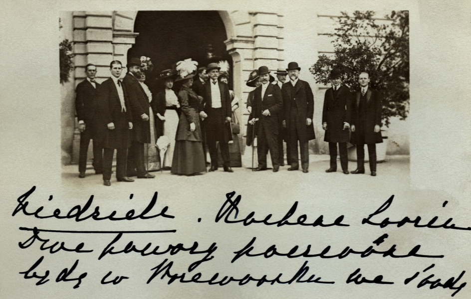 Na zdjęciu znajduje się grupa osób przed wejściem na zamek.