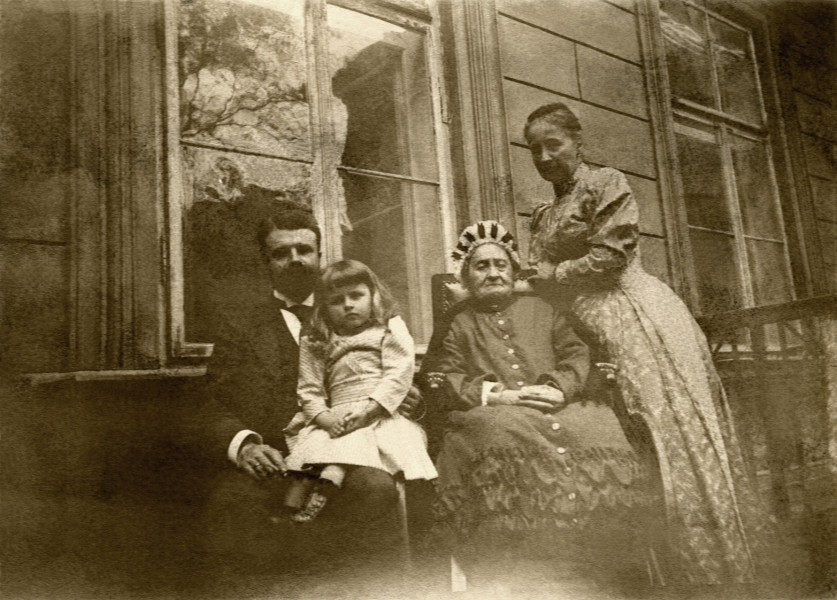 Na zdjęciu znajduje się cztery osoby przed ścianą pałacu.