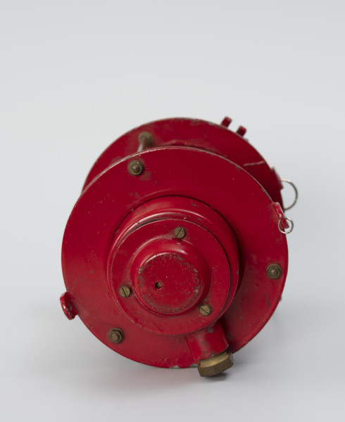 Elektryczna latarnia okrętowa - ujęcie z dołu; Latarnia elektryczna. Spodnie wieko przykręcone na trzy śruby. 2 uchwyty, umieszczone na przeciwko siebie.