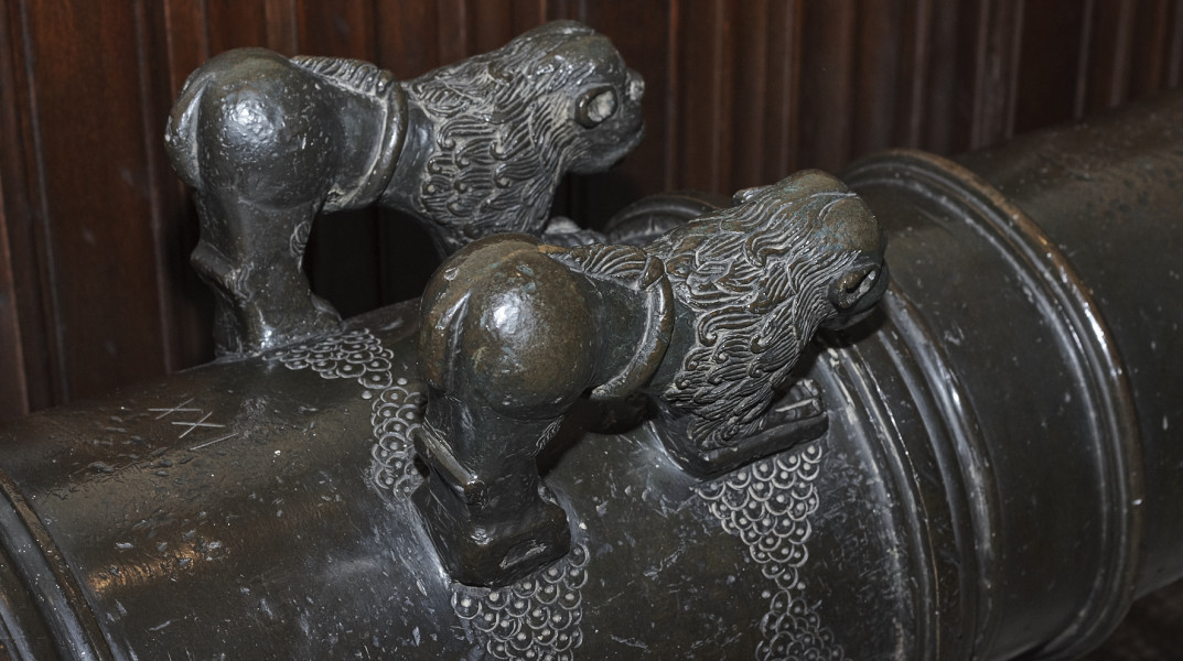 Zdjęcie przedstawia dwa lwy które zdobią lufe armatnią.