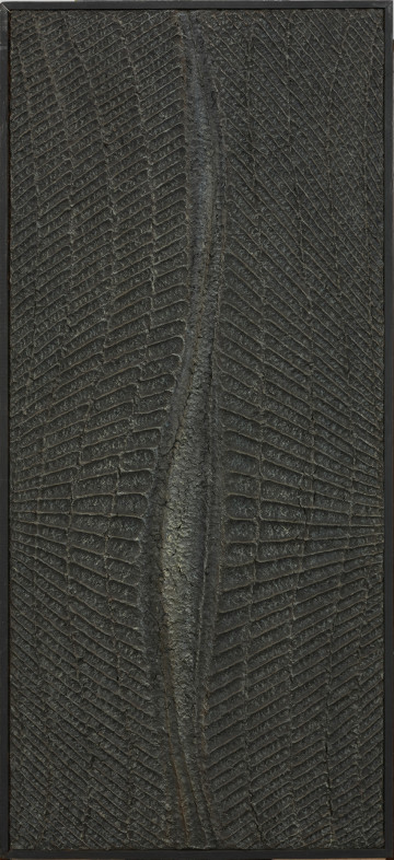 malarstwo; obraz; Obraz pionowy I - Ujęcie z przodu obrazu w ramie. Kompozycja reliefowa, monochromatyczna. Centralnie przez wysokość obrazu w pionie przebiega falista, smukła forma, przypominajaca pęknięcie. Nieco poniżej środka rozszerza się i wybrzusza, ukazując popękaną powierzchnię, po czym znów zwęża się i schodzi ku dolnej krawędzi pionowymi wypukłymi liniami. Z lewej i prawej strony fakturowe układy symetrycznych sfałdowanych prążkowań, nawiązujących do regularnie ustrukturyzowanych biologicznych komórek, w górze obrazu ukośnie wznoszą się, w dole opadają. Punkt ich zbiegu znajduje się poza krawędziami kompozycji, poniżej połowy szerokości obrazu. Całość polichromowana czernią.