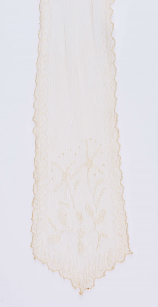 E/124/MRK/ML - Czepek tiulowy, biały tiul, wzory o motywach roślinnych, brzegi pofałdowane. Dług. wstążek 45 cm, szer. 8 cm, brzegi obszyte białą koronką szer. 1 cm. Czepek dł. 50 cm szer. 18 cm. W części środkowej wstawka szer. 10 cm.