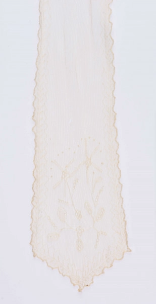 E/124/MRK/ML - Czepek tiulowy, biały tiul, wzory o motywach roślinnych, brzegi pofałdowane. Dług. wstążek 45 cm, szer. 8 cm, brzegi obszyte białą koronką szer. 1 cm. Czepek dł. 50 cm szer. 18 cm. W części środkowej wstawka szer. 10 cm.