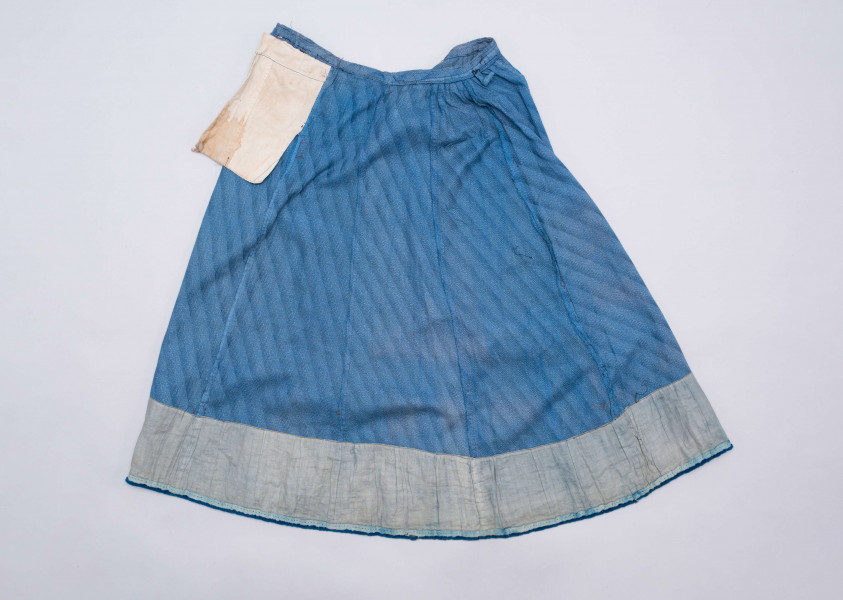 E/189/MRK/ML - Spódnica ze szczoteczką koloru niebieskiego. Obwód w pasie 72 cm. Obwód spódnicy u dołu 223 cm, od spodu obszyta niebieską szczoteczką. Z przodu wiązana na 2 sznurki.