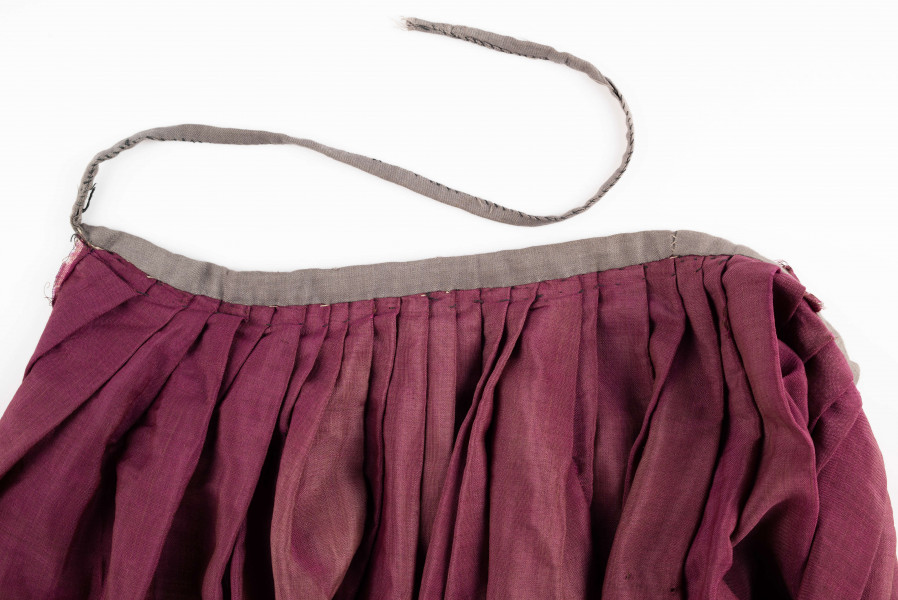 E/190/MRK/ML - Spódnica ze szczoteczką koloru biskupiego. Szyta ręcznie czarnymi nićmi. Spód obszyty szczoteczką. Obwód w pasie 67 cm. Obwód u dołu 322 cm. 