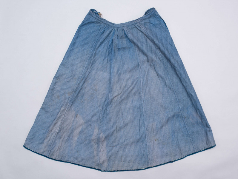 E/189/MRK/ML - Spódnica ze szczoteczką koloru niebieskiego. Obwód w pasie 72 cm. Obwód spódnicy u dołu 223 cm, od spodu obszyta niebieską szczoteczką. Z przodu wiązana na 2 sznurki.