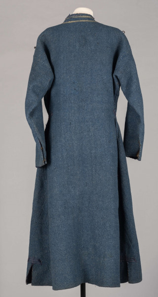 E/308/MRK/ML - Sukmana męska szaro-granatowa z metalowymi guzikami. Kołnierz - stójka dł. 43 cm, szer. 5 cm, rękaw wszywany prosty dł. 56 cm, szer. 15 cm. Krój prosty, w pasie po obu stronach zaszewki /13/, lniana podszewka, sukmana zapina na 6 haftek, ozdobiona taśmą szer. 1 cm i metalowymi guzami /7/. Dł. 123 cm, szer. 49 cm.