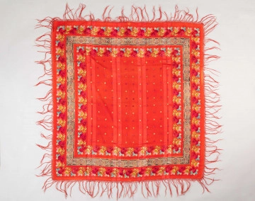 E/129/MRK/ML E/129/MRK/ML - Chustka wełniana różnokolorowa z frędzlami w kolorze czerwonym. Dł. 152 cm, szer. 148 cm. Na całej powierzchni chusty motywy kwiatów. na czarnym tle kwiaty w kolorach: żółty, czerwony, różowy, niebieski. Dł. frędzli 17 cm.