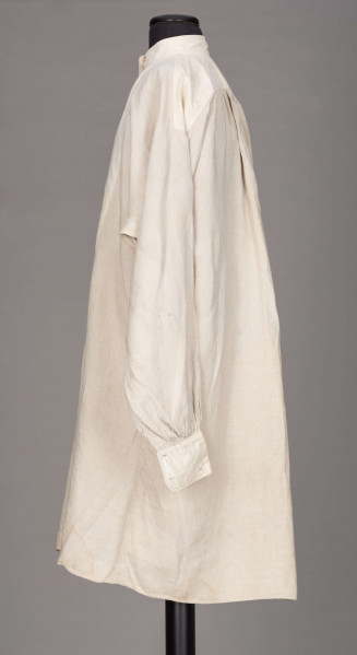 E/128/MRK/ML - Koszula lniana męska, biała, prosty i krótki kołnierzyk zapinany na 2 guziki, rękawy długie zapinane na 2 guziki. Dł. 101 cm, szer. 54 cm. Dł. rękawa 57 cm, szer. 20 cm, dł. mankietu 5 cm, szer. 11 cm. Z przodu koszuli rozcięcie  dł. 37 cm.  