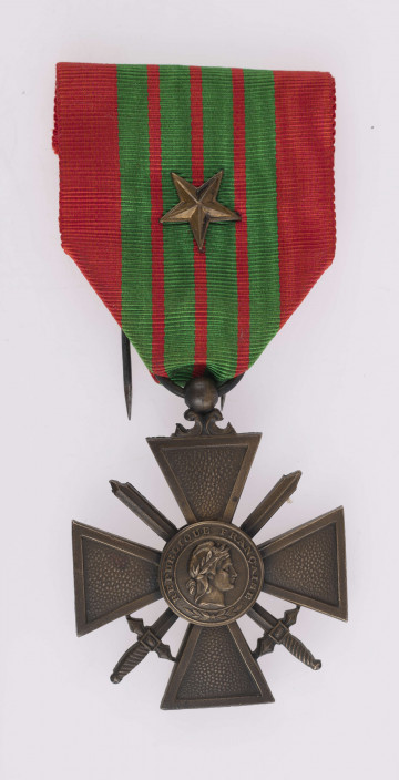 H/2464/MRK/ML - Odznaką jest krzyż bity w brązie, o groszkowanych i obramowanych ramionach. Między ramionami skrzyżowane miecze, w środku nałożona okrągła tarcza z profilem głowy rycerza antycznego w otoku napis, narewersie tarcza z datą 1940.
