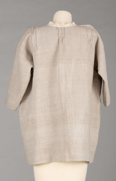 E/529/MRK/ML - Koszula damska. Uszyta z lnianego płótna z długimi rękawami, pod szyją dziurkowa pliska w kolorze białym. Na linii ramienia symetryczne zaszewki, pod szyjką pęknięcie zapinane na guzik.