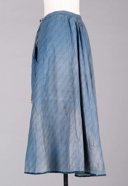 E/189/MRK/ML - Spódnica ze szczoteczką koloru niebieskiego. Obwód w pasie 72 cm. Obwód spódnicy u dołu 223 cm, od spodu obszyta niebieską szczoteczką. Z przodu wiązana na 2 sznurki.