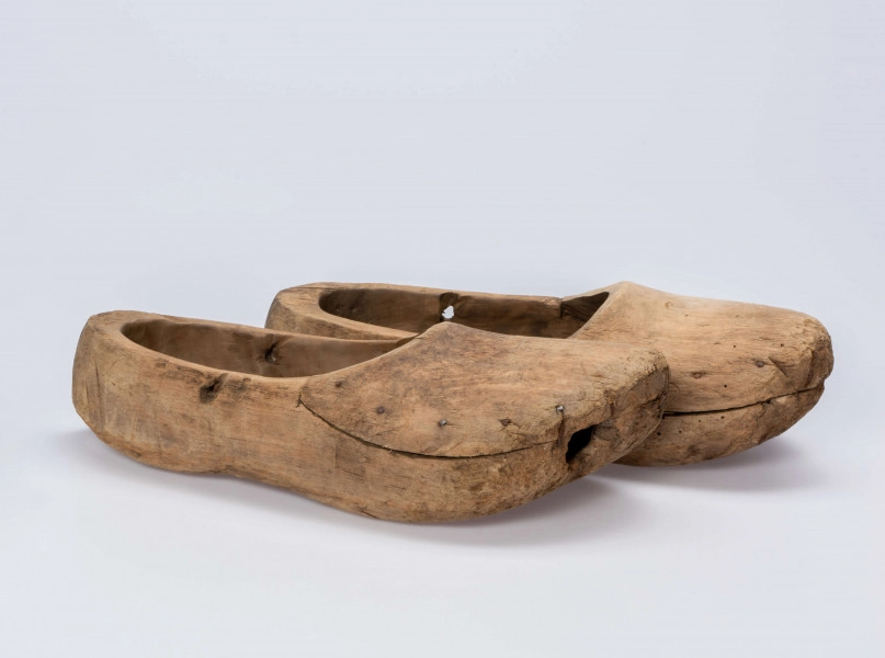 E/13/MRK/ML - Drewniaki dłubane, para. Długość 31 cm. Zrobione z dwóch kawałków drewna zbitych gwoździami. Z boku otwory do wiązania.