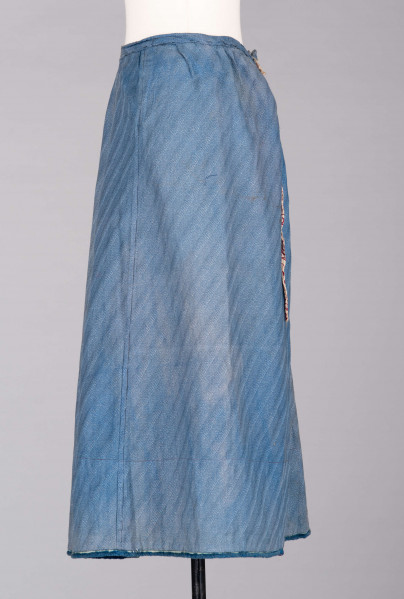 E/189/MRK/ML - Spódnica ze szczoteczką koloru niebieskiego. Obwód w pasie 72 cm. Obwód spódnicy u dołu 223 cm, od spodu obszyta niebieską szczoteczką. Z przodu wiązana na 2 sznurki.