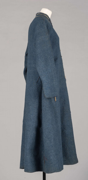 E/308/MRK/ML - Sukmana męska szaro-granatowa z metalowymi guzikami. Kołnierz - stójka dł. 43 cm, szer. 5 cm, rękaw wszywany prosty dł. 56 cm, szer. 15 cm. Krój prosty, w pasie po obu stronach zaszewki /13/, lniana podszewka, sukmana zapina na 6 haftek, ozdobiona taśmą szer. 1 cm i metalowymi guzami /7/. Dł. 123 cm, szer. 49 cm.