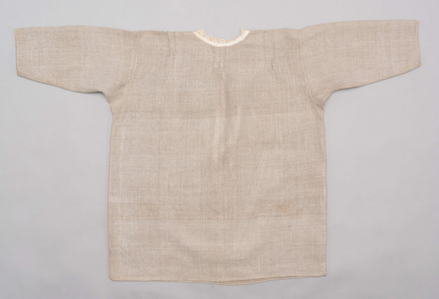 E/529/MRK/ML - Koszula damska. Uszyta z lnianego płótna z długimi rękawami, pod szyją dziurkowa pliska w kolorze białym. Na linii ramienia symetryczne zaszewki, pod szyjką pęknięcie zapinane na guzik.