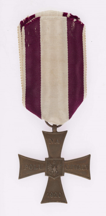 H/2459/MRK/ML - Krzyż Walecznych bity w brązie, na awersie w środku tarcza z orłem, na ramionach krzyża NA/ POLU/CHWAŁY/1920. Na rewersie Napis WALECNYM iw pionie miecz z wieńcem laurowym. Wstążka biała z amarantowymi paskami.
