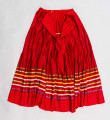 E/516/MRK/ML - Spódnica krakowska. Wykonana z wełenki, kolor czerwony. W dolnej czesci spódnica ozdobiona różnokolorowymi tasiemkami, sztuk 7. Przy oszewce lekko marszczona.