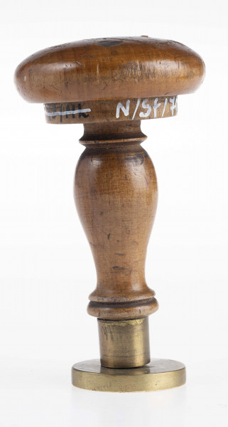 W dolnej części tłoka ukośnie umieszczone obok siebie dwie tarcze z herbami: Jelita i Łada. Herb Jelita zwienczony otwartą koroną i klejnotem; herb Łada ukoronowanym małym hełmem i klejnotem. Nad tarczami Oko Opatrzności w promienistej glorii. Obramowanie gładkim otokiem.
