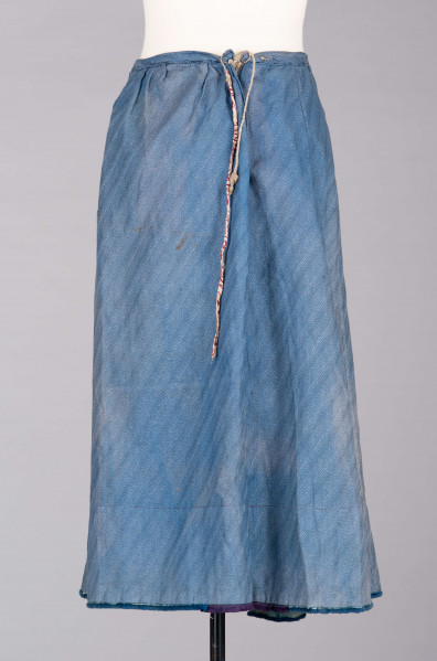 E/189/MRK/ML - Spódnica ze szczoteczką koloru niebieskiego. Obwód w pasie 72 cm. Obwód spódnicy u dołu 223 cm, od spodu obszyta niebieską szczoteczką. Z przodu wiązana na 2 sznurki.