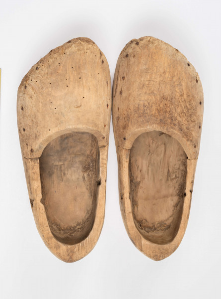 E/13/MRK/ML - Drewniaki dłubane, para. Długość 31 cm. Zrobione z dwóch kawałków drewna zbitych gwoździami. Z boku otwory do wiązania.