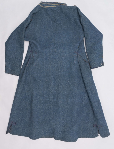 E/308/MRK/ML - Sukmana męska szaro-granatowa z metalowymi guzikami. Kołnierz - stójka dł. 43 cm, szer. 5 cm, rękaw wszywany prosty dł. 56 cm, szer. 15 cm. Krój prosty, w pasie po obu stronach zaszewki /13/, lniana podszewka, sukmana zapina na 6 haftek, ozdobiona taśmą szer. 1 cm i metalowymi guzami /7/. Dł. 123 cm, szer. 49 cm.