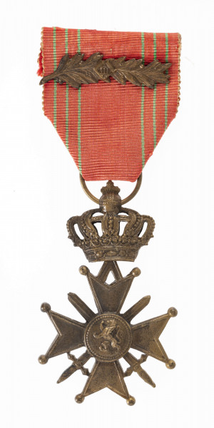 Odznaką Croix de Guerre jest krzyż równoramienny o wym. 3,8 x 3,8 cm. Ramiona krzyża matowe z obramowaniem, rozszerzają się od 0,5 do 1,7 cm, zakończone kulkami, z trójkątnym wcięciem. Pomiędzy ramionami skrzyżowane dwa miecze długości 3,5 cm. Medalion krzyża mocno uwypuklony z herbem Belgii (lew wspięty na tylych nogach). Przy górnym ramieniu przywieszka zawiasowo połączona z zamkniętą koroną ośmioramienną, zwieńczoną kulą z krzyżem. Korona w przekroju poziomym eliptyczna. W kulistym zwieńczeniu korony otwór z przełożonym kółkiem. Wstążka odznaczenia szerokości 3,8 cm czerwona z sześcioma zielonymi paskami i nałożoną  poziomo gałązką palmową.